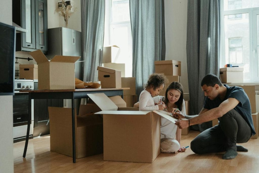 family unpacking moving boxes