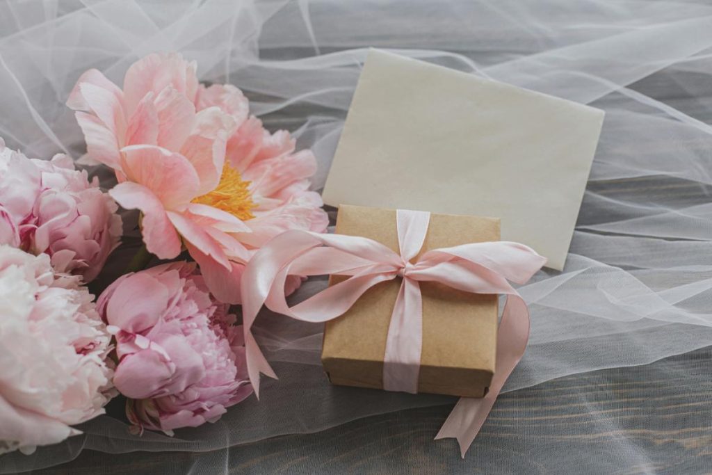 flowers and gift box on bed