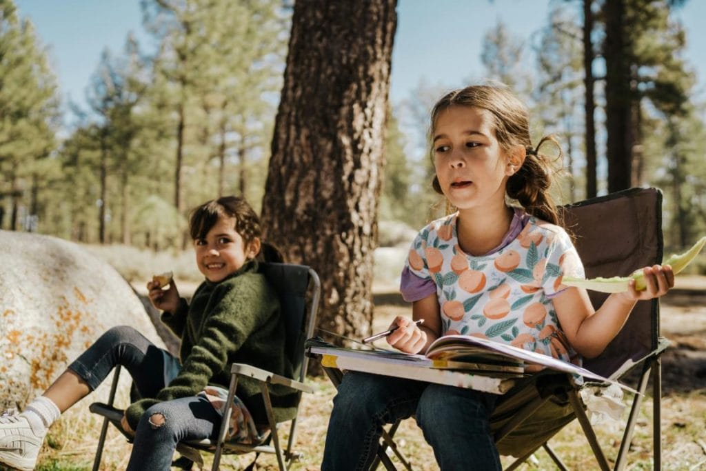 two little girls sitting in camping chairs