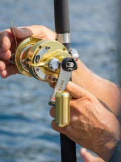 close up of fishing reel in man's hands