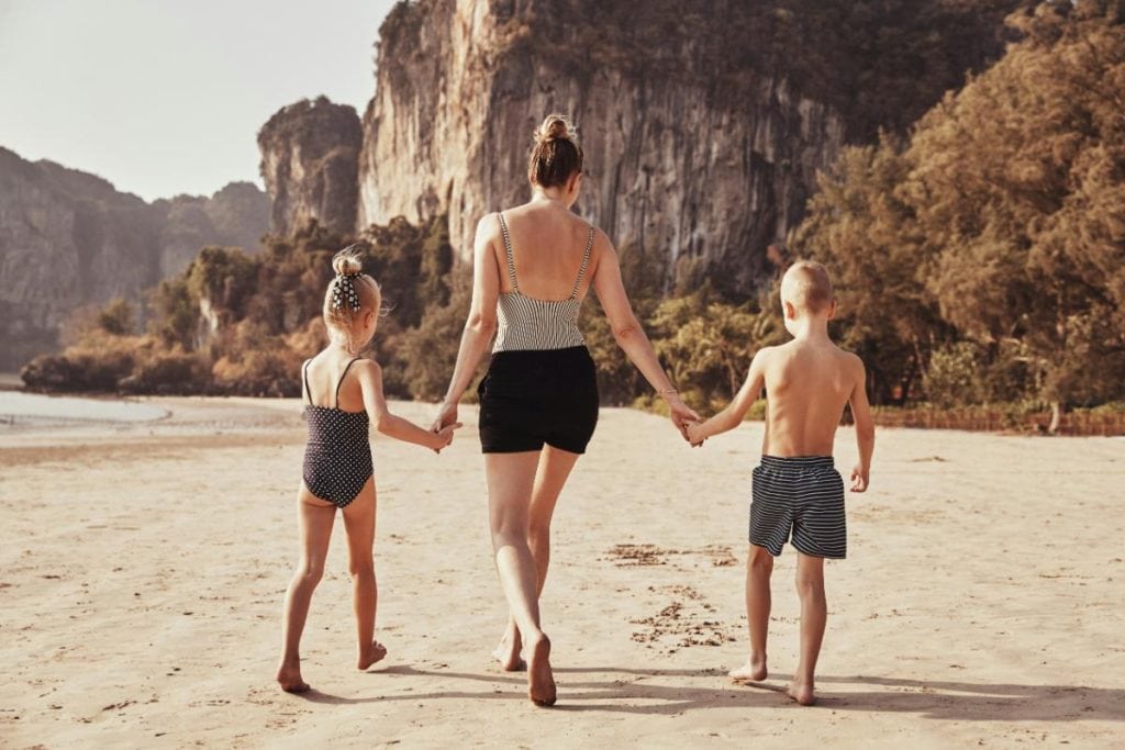 mom walking with son and daughter on the beach