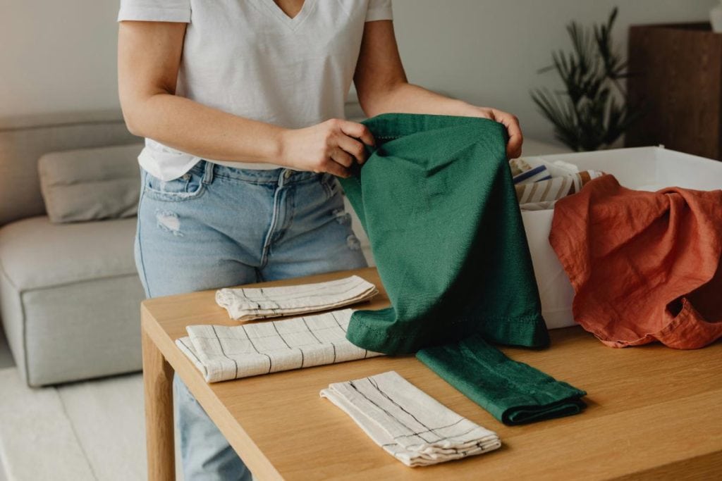 woman folding and putting away towels or linens