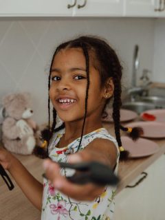 little girl holding utensils