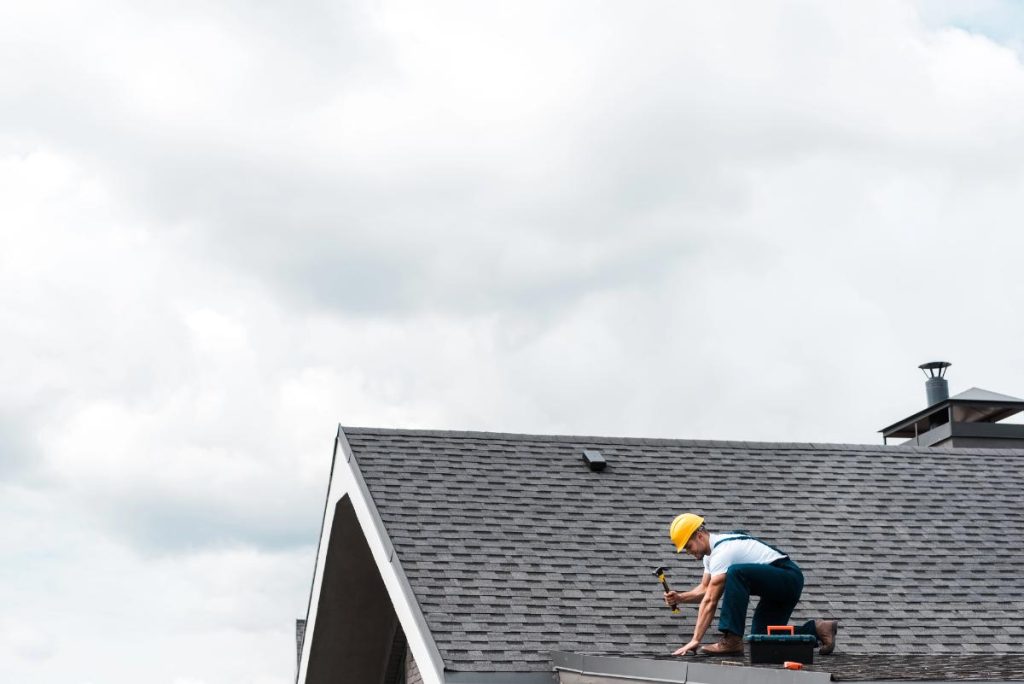 worker on a roof against a cloudy sky