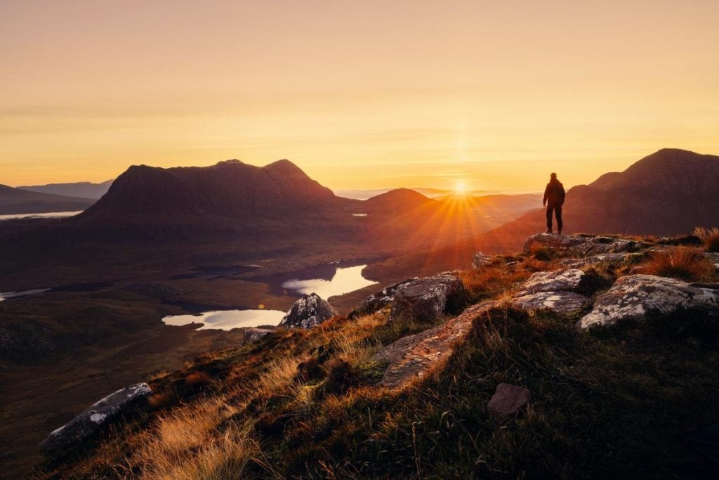 man looking at sunset in the wilderness