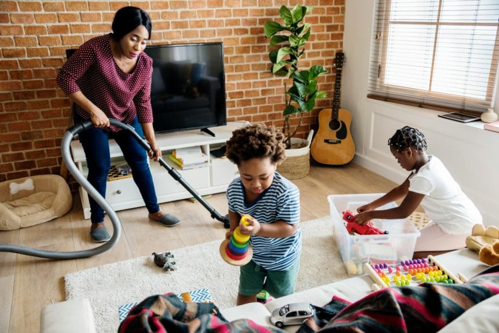 mom and kids tidying up the living room