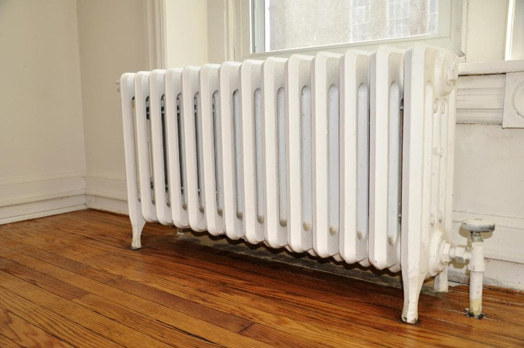 old radiator in room with wood floor