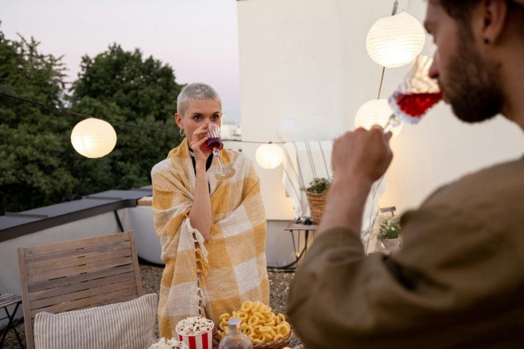 people outdoors with popcorn and wine