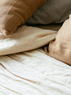 pillows and sheets in muted tones on a bed