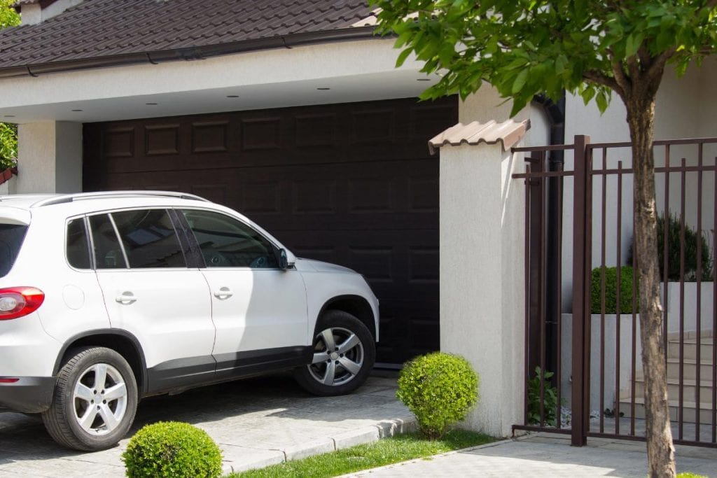 white car in front of garage door at home