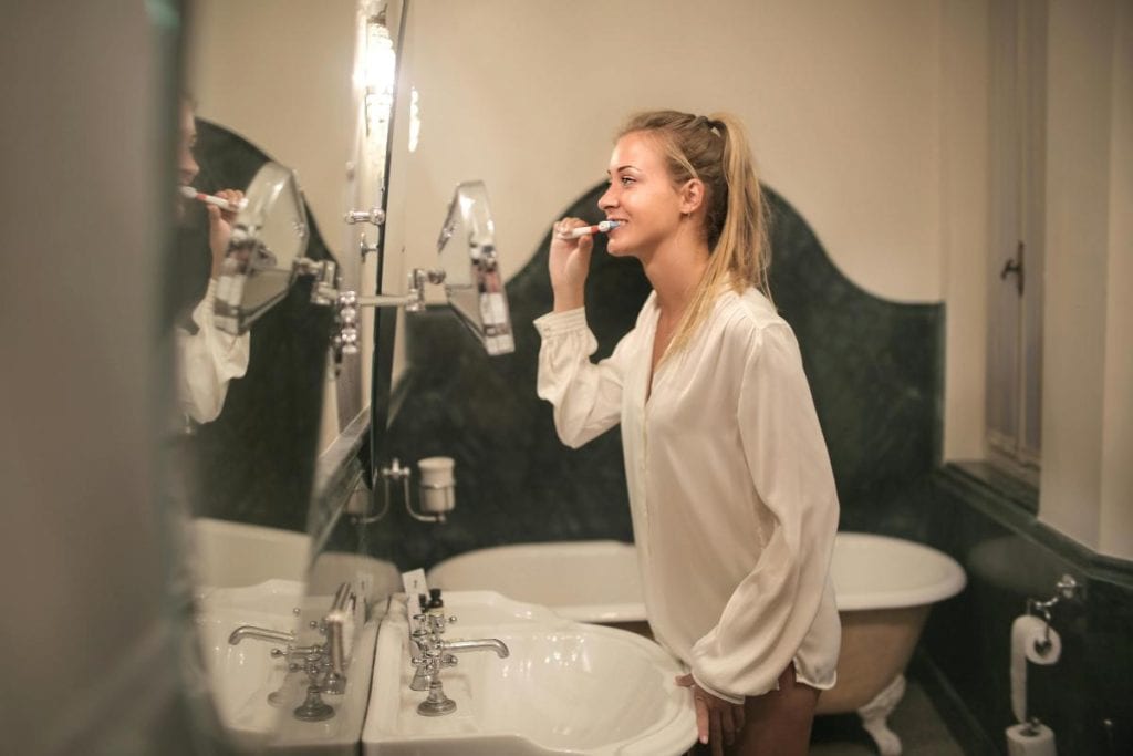 blonde woman brushing her teeth