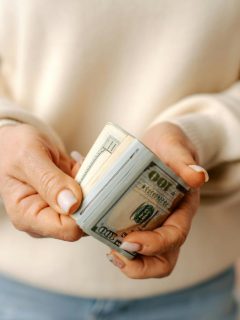 woman holding a roll of cash