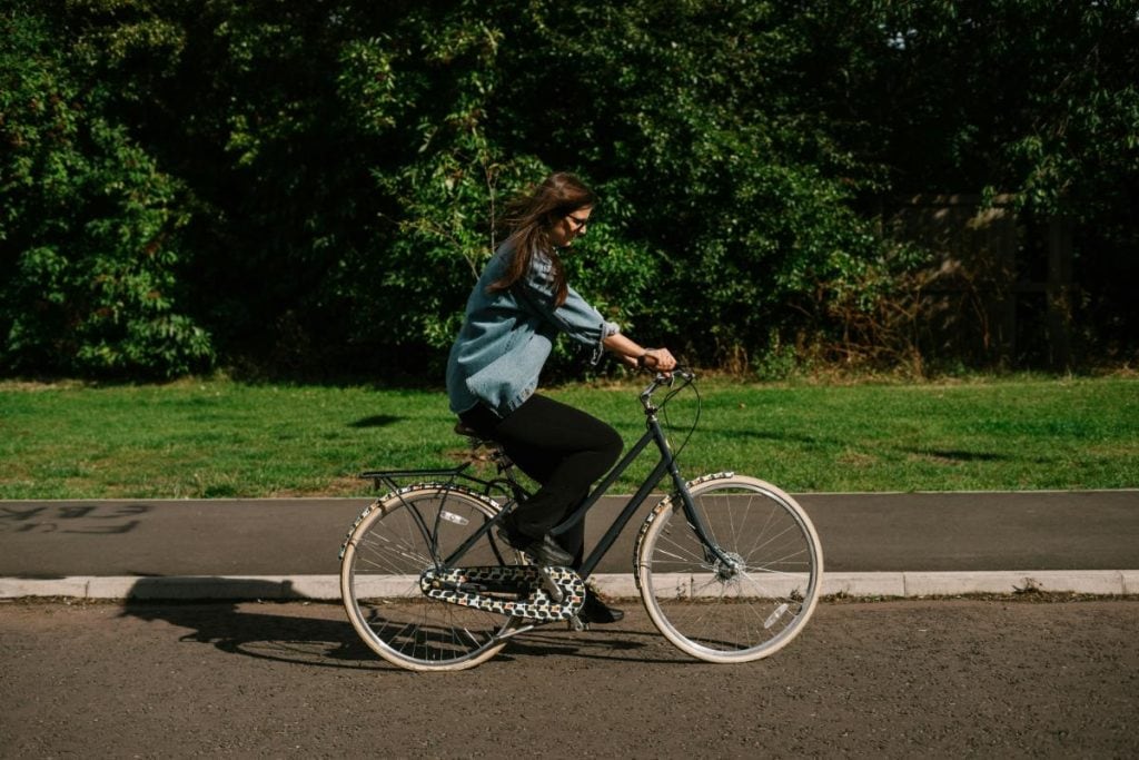 woman riding bicycle along a street