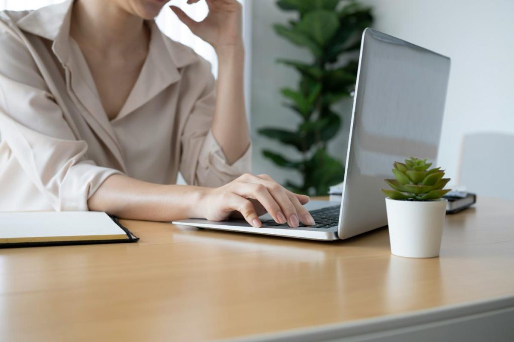 faceless woman typing on laptop