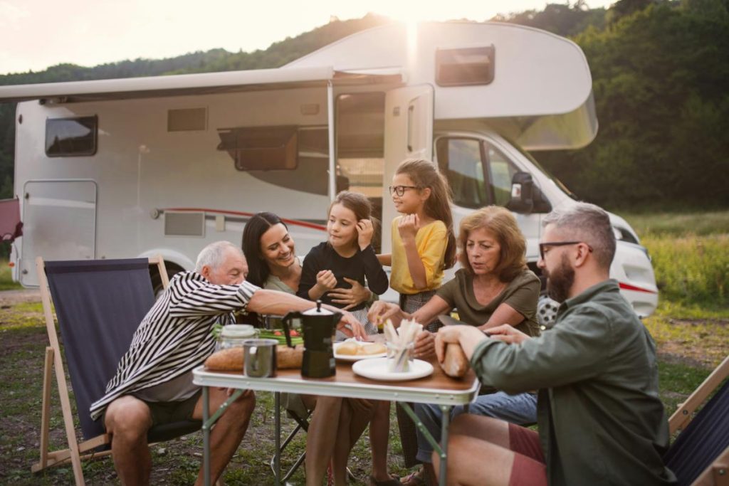 family sitting at table in front of RV