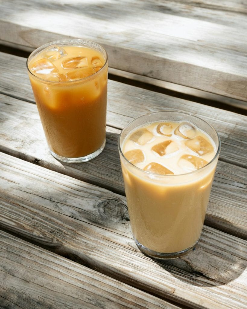 two cups of iced coffee on a wooden table