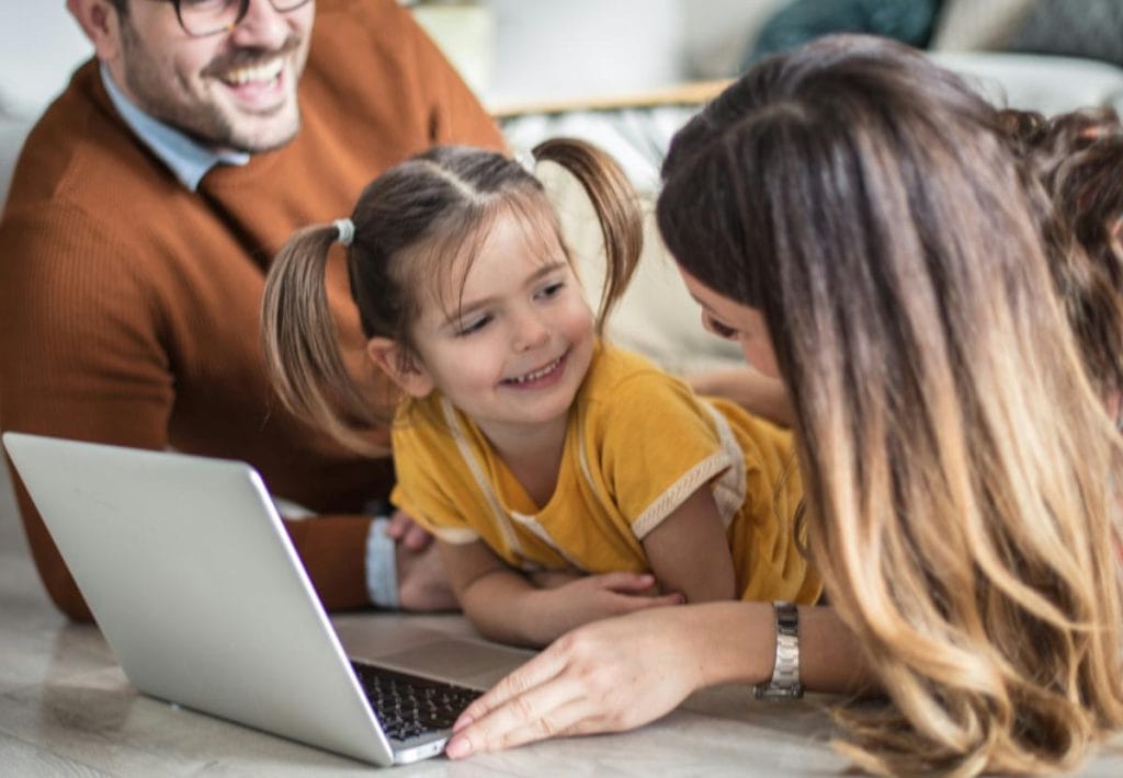 parents and daughter using laptop