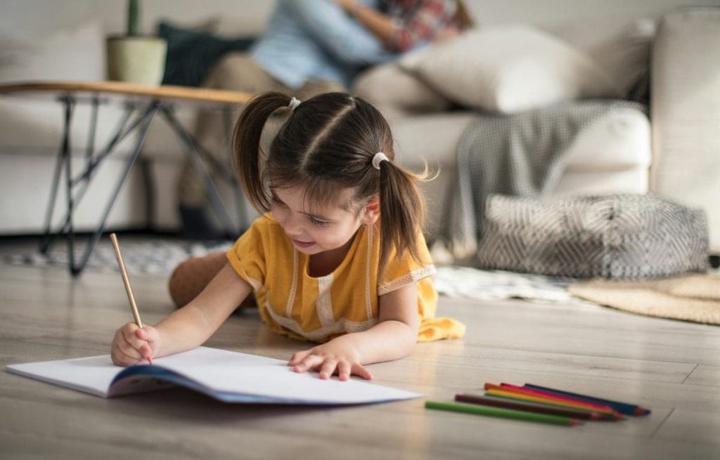 little girl writing in notebook