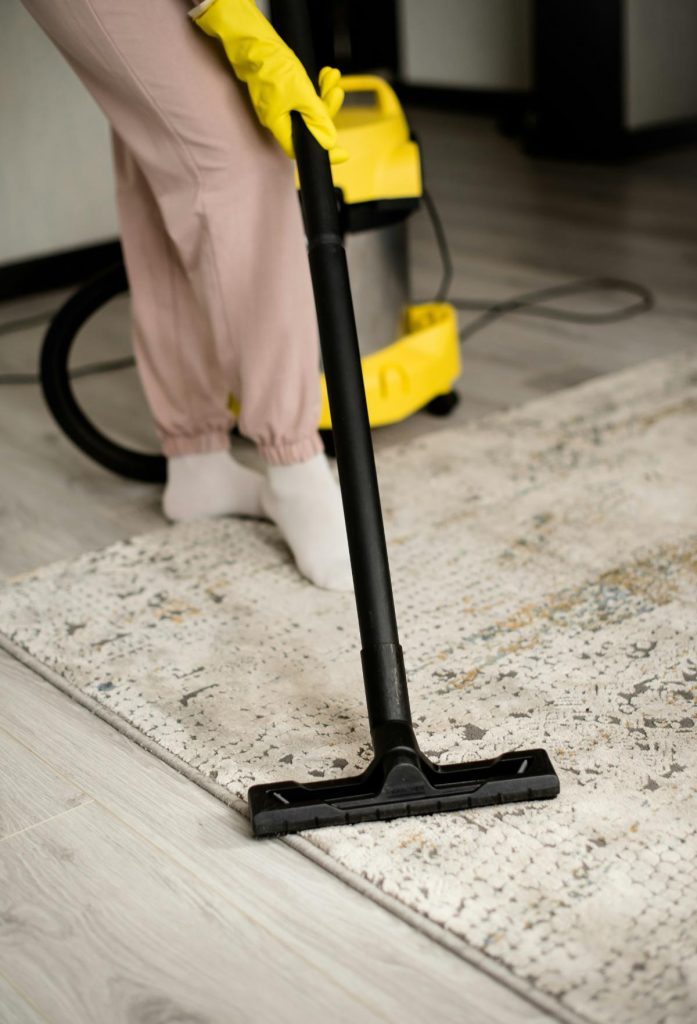 person vacuuming a rug