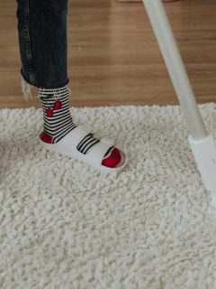 person vacuuming a white rug