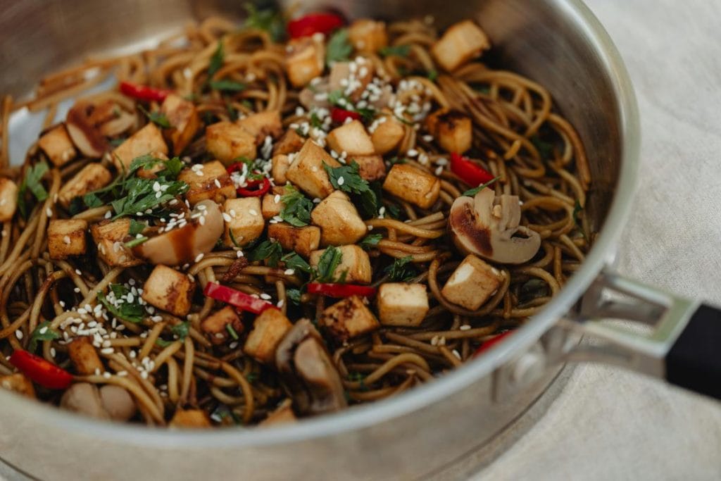 vegetarian food in a skillet - tofu, noodles, and mushrooms