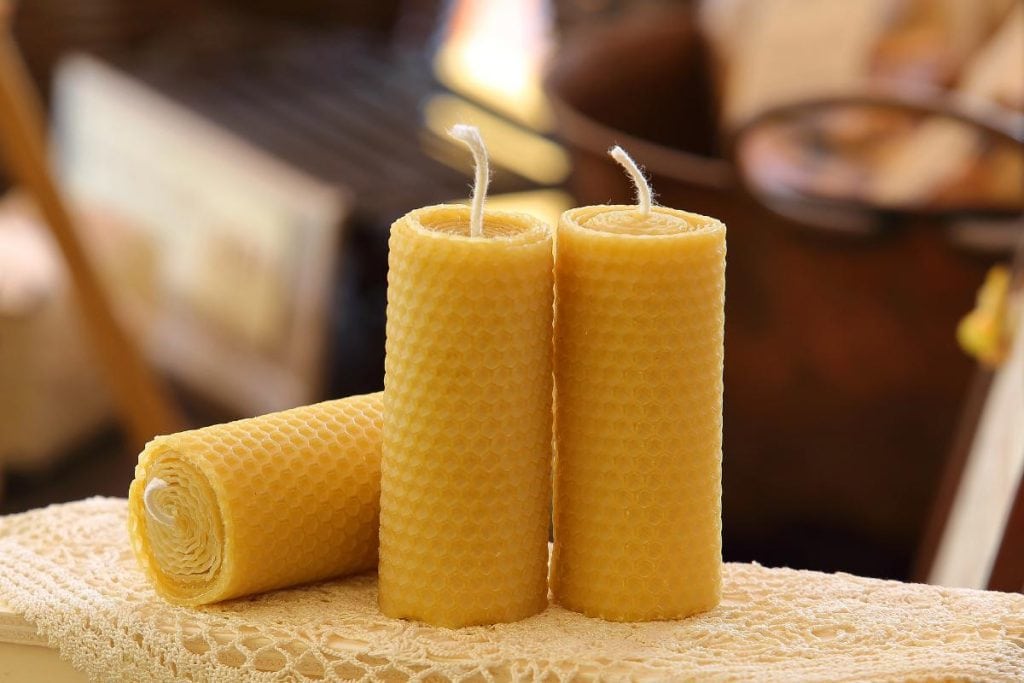 three unlit beeswax candles