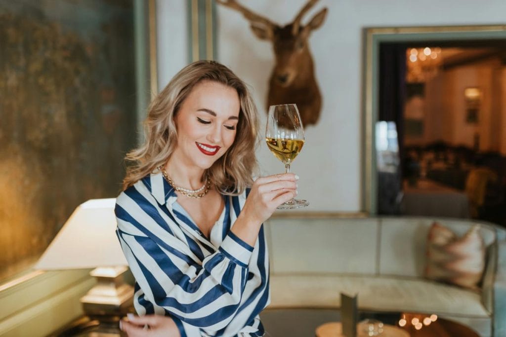 blonde woman enjoying a glass of white wine