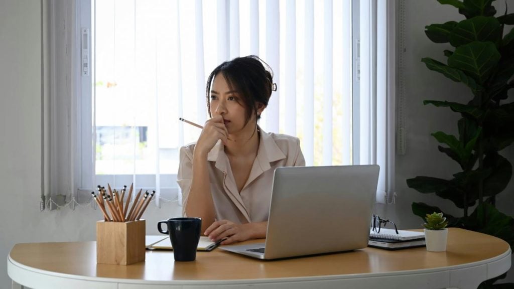 businesswoman with laptop deep in thought