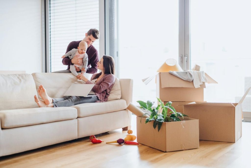 couple with baby unpacking boxes after a move