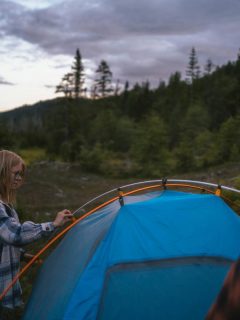 couple setting up a blue tent