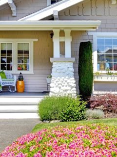cute house with manicured lawn and large window