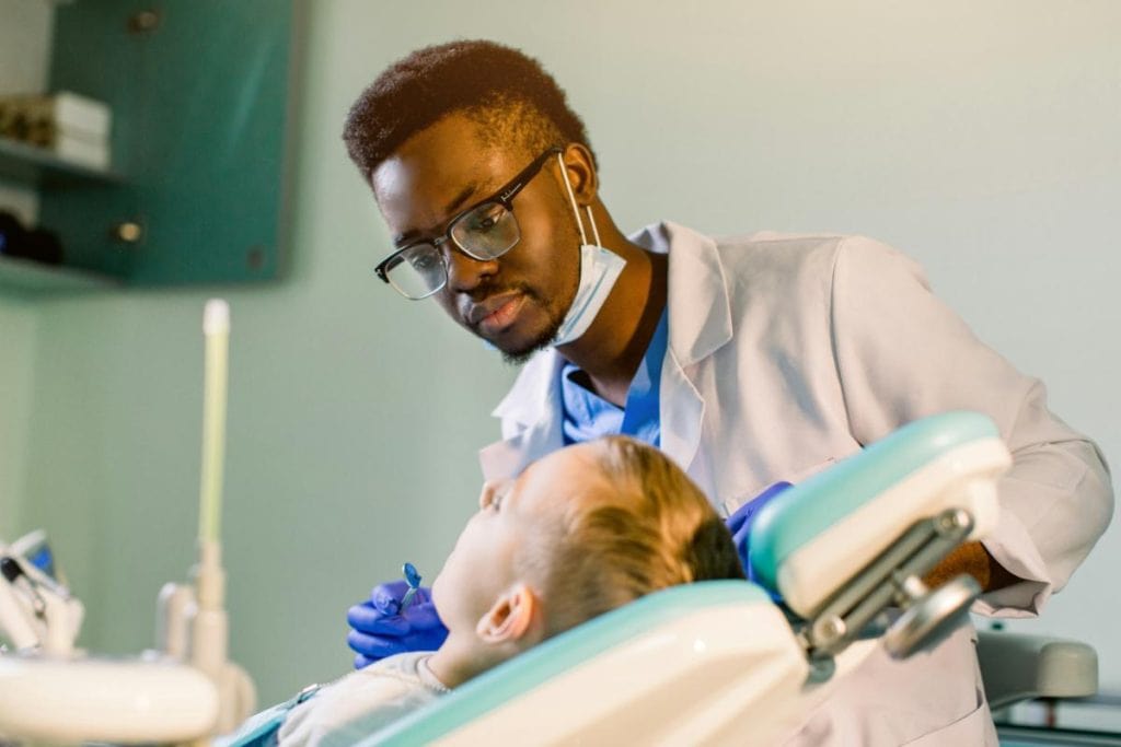 dentist examining boy's teeth