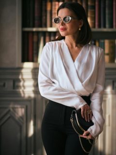 elegant woman in white blouse, black skirt, and sunglasses