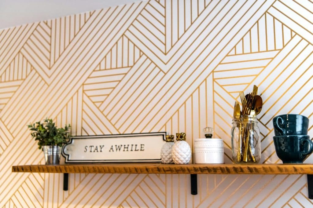 wallpapered wall with shelf and decorative accessories