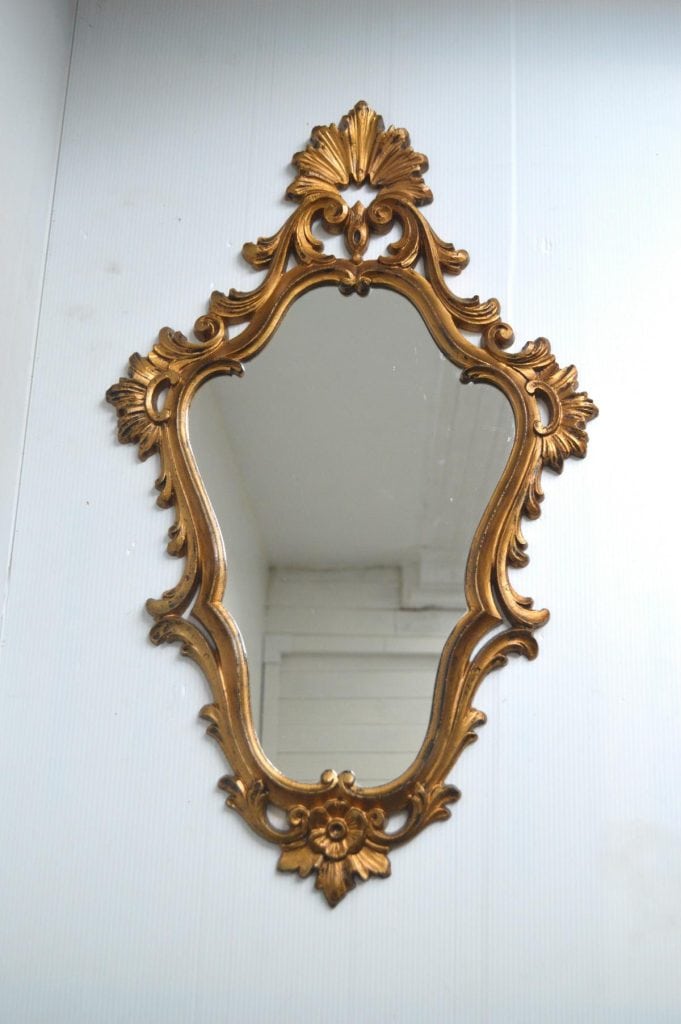 statement mirror hanging on white wall