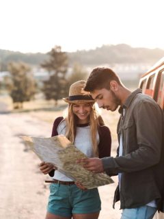 couple looking at a map beside their van