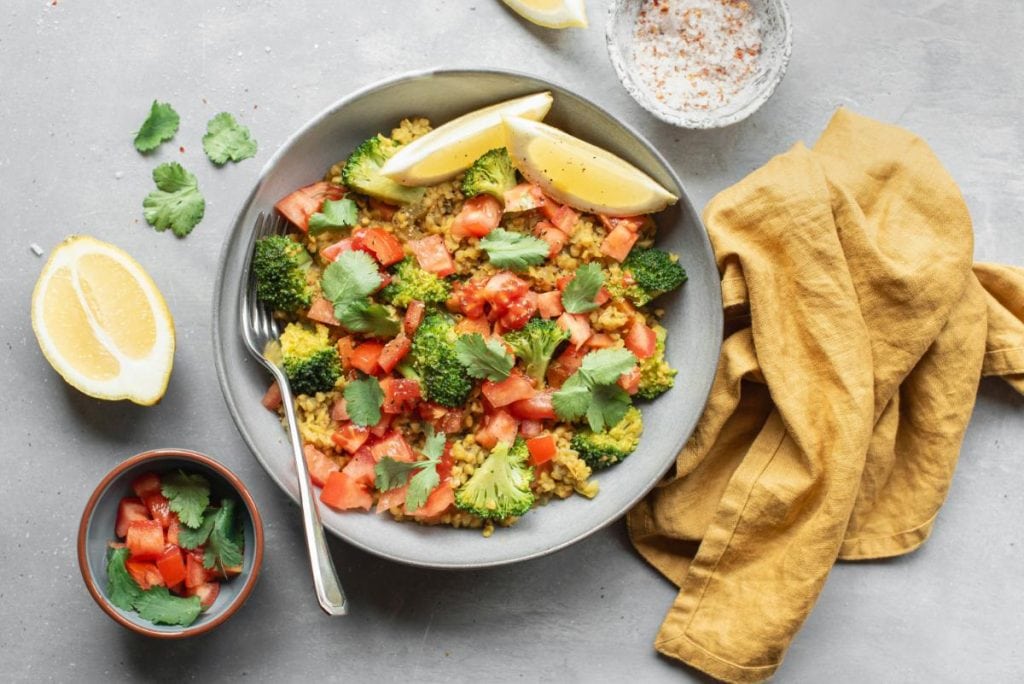 bowl of vegan food with broccoli and tomatoes