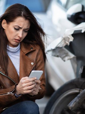 woman sending a text message after a car crash