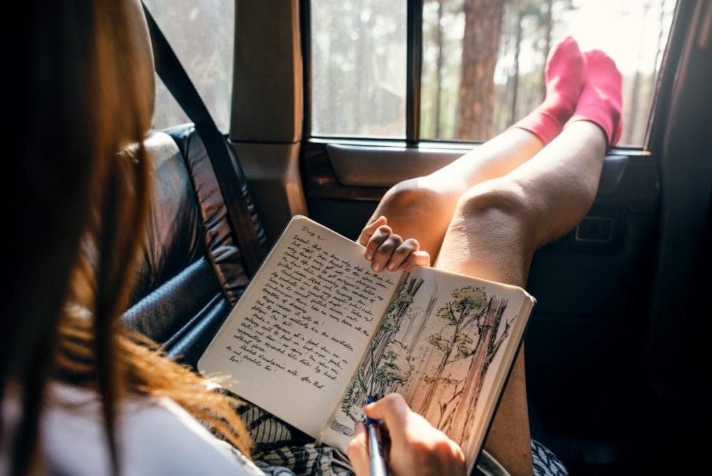 woman writing in a travel journal
