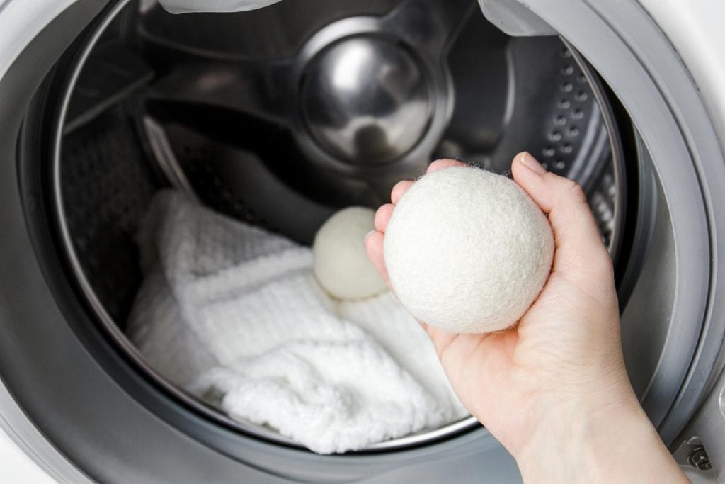 woman putting wool dryer balls in dryer