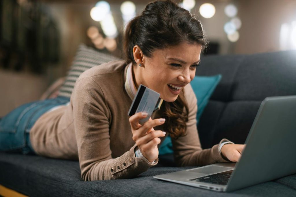 woman using laptop and gift card to shop online
