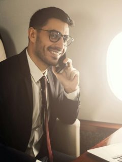 businessman on private jet talking on phone
