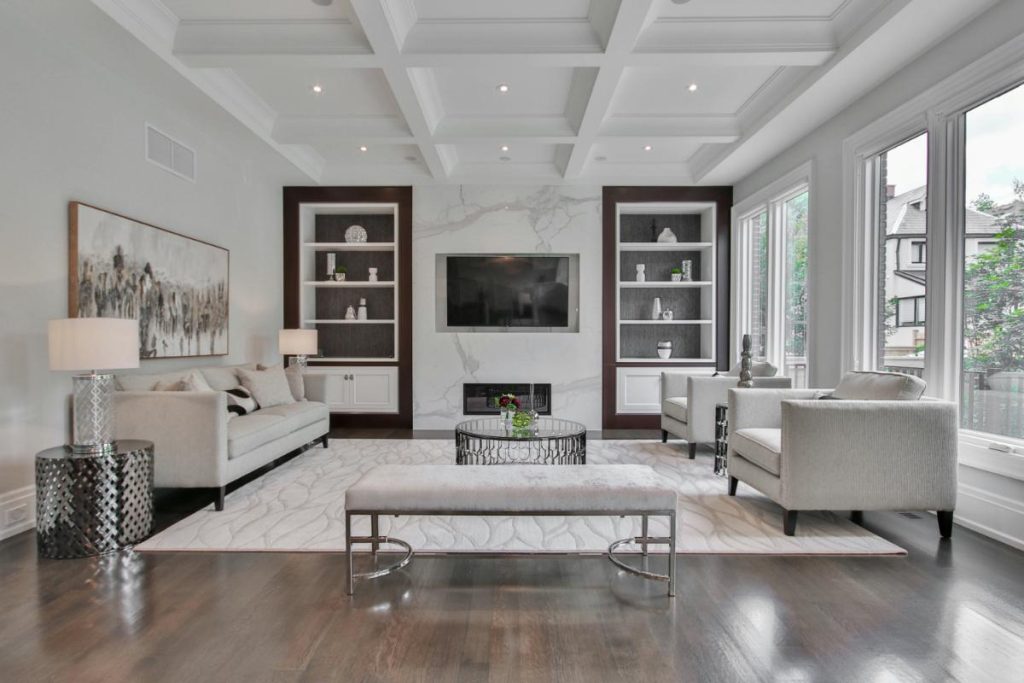 Elegant modern living room with natural light, neutral furniture, and a simple floral arrangement on a glass coffee table for a fresh, inviting feel.