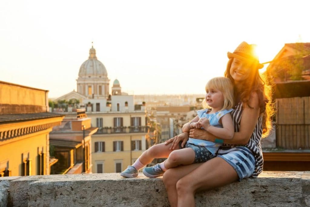 Mother and daughter enjoying sunset views of Rome's historic rooftops during a European family vacation
