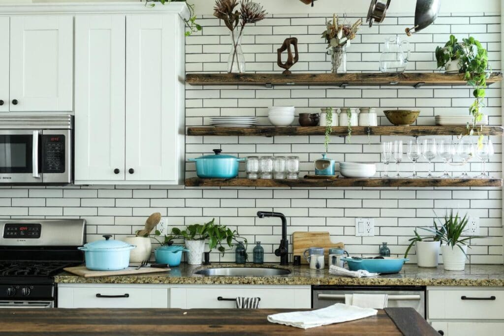 Modern small kitchen with open wooden shelving, white subway tile backsplash, and space-saving design ideas perfect for renovations for small residential spaces.