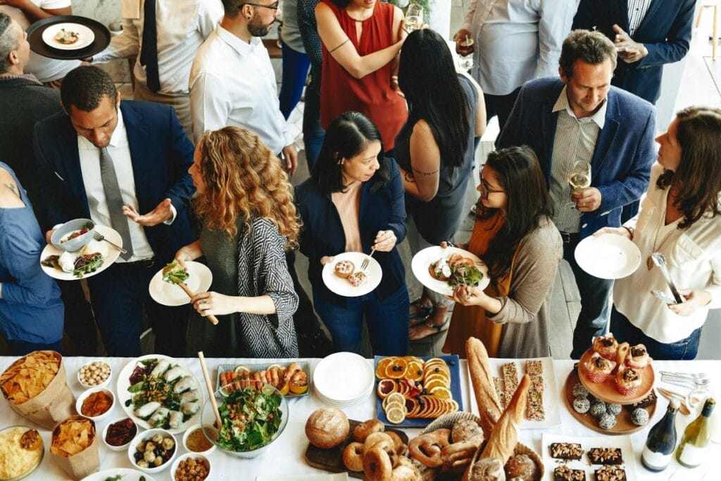 people serving themselves food at a catered event