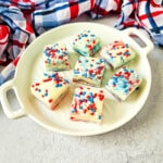Tray of marble-swirled patriotic fudge squares with red, white, and blue colors, highlighted by festive candy sprinkles—an easy dessert for July 4th gatherings.