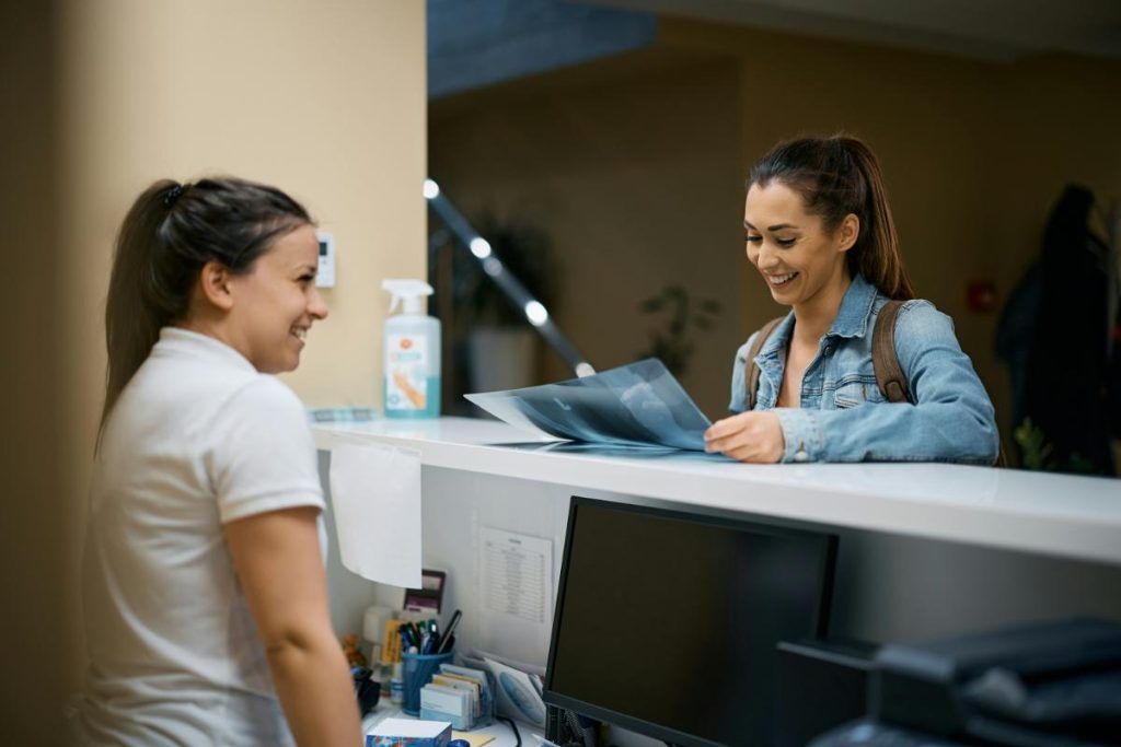 smiling woman looking at xray photo while talking to nurse