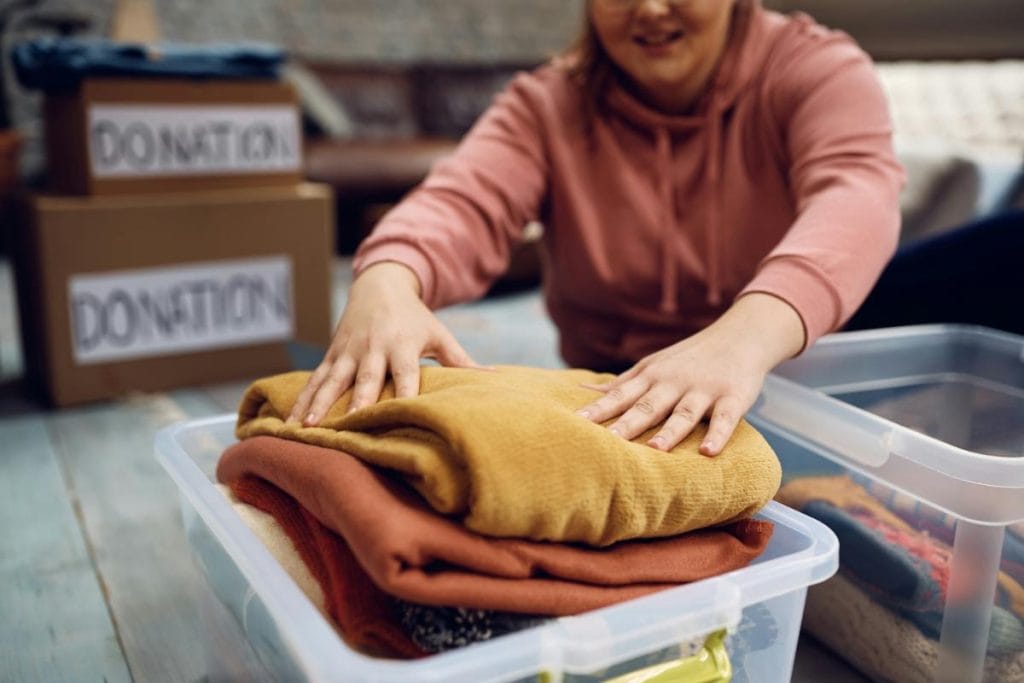 woman putting clothes in a box for donation