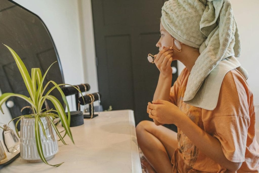 woman using a roller on face - everyday grooming habits that make a big difference
